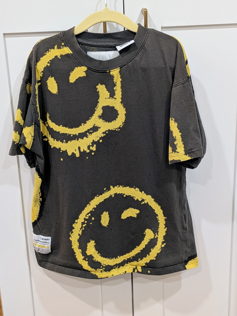 Ara Black Tee with Yellow Smiley Graphic
